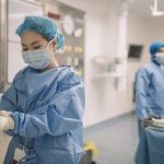 an asian chinese female surgeon doctor is wearing surgical gloves before the surgery in operating room