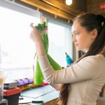 Female engineer examining prosthesis hand project in workshop.